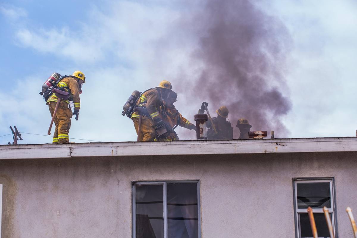 pompieri che spengono incendio sul tetto di una casa